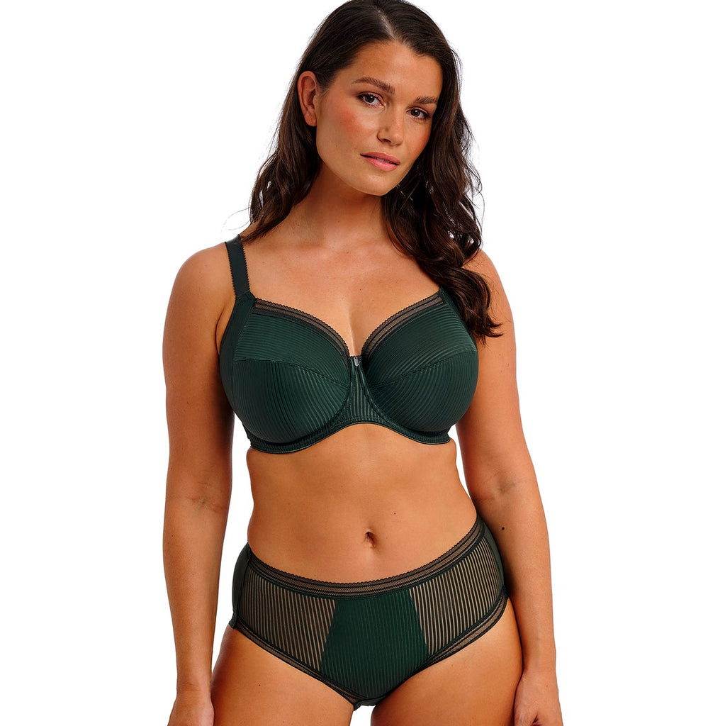 Woman wearing a green bra and panties set on a white background