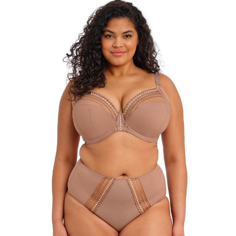Woman wearing a beige bra and panties set on a white background